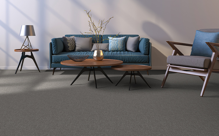 living room area with a grey carpet and green couch